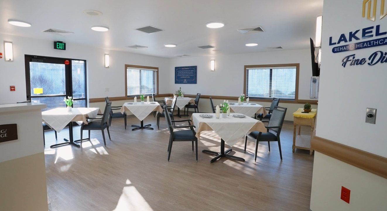 The Lakeland dining room, tables laid with white linen and tulips under the Fine Dining sign